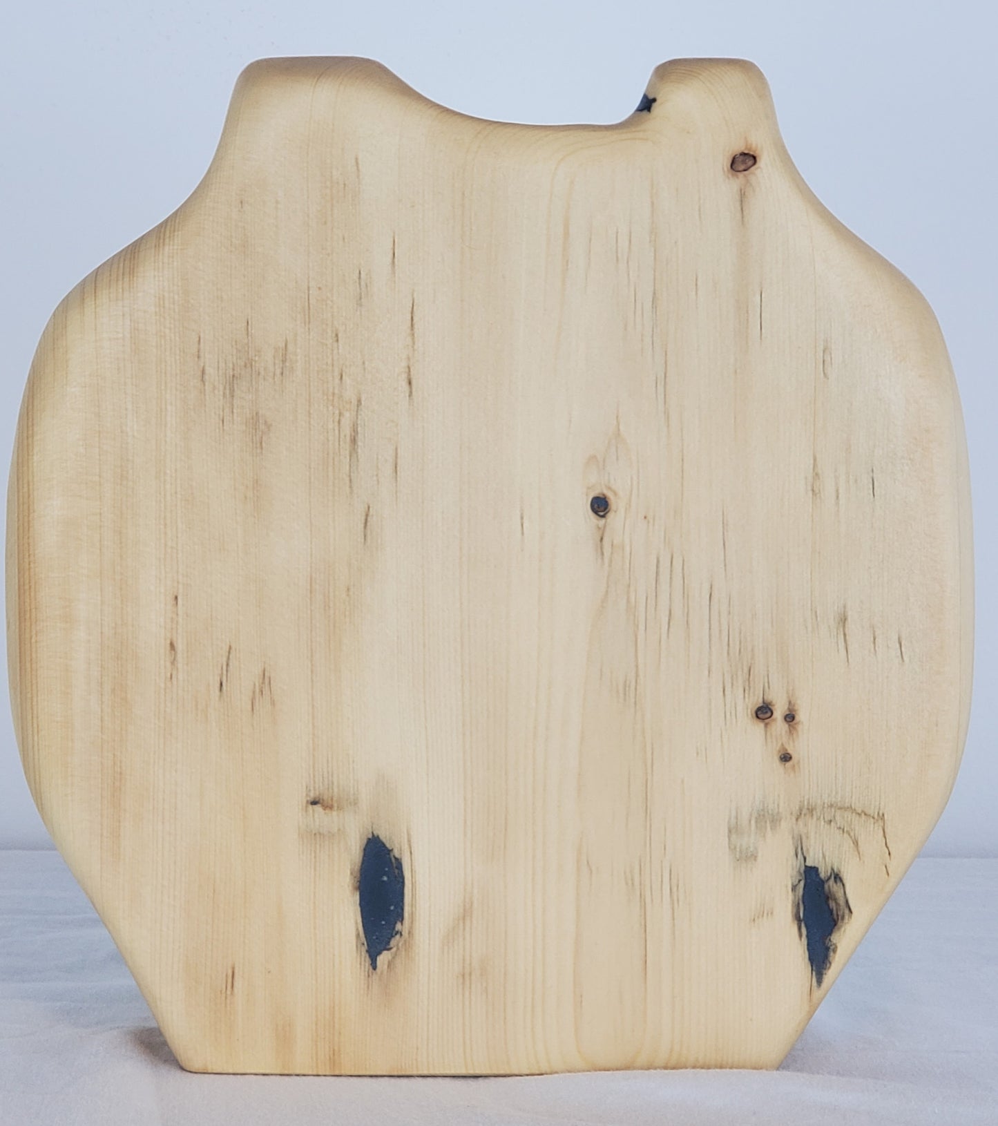 Wooden vase with a natural, slightly rough texture on a light gray background