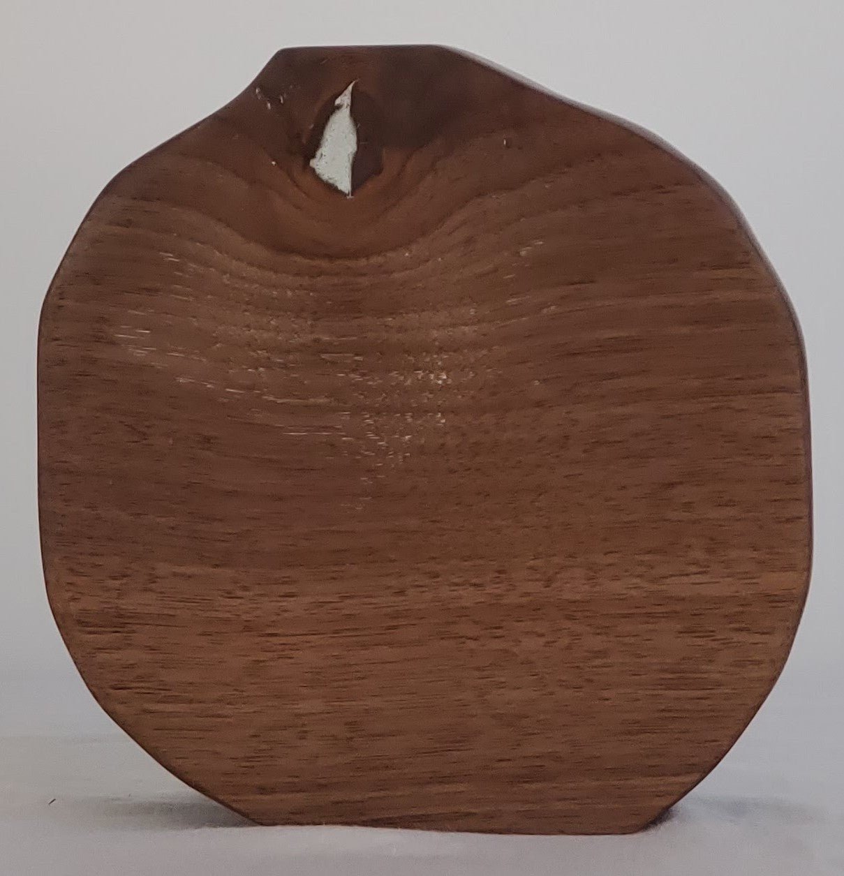 Wooden apple-shaped object on a gray background