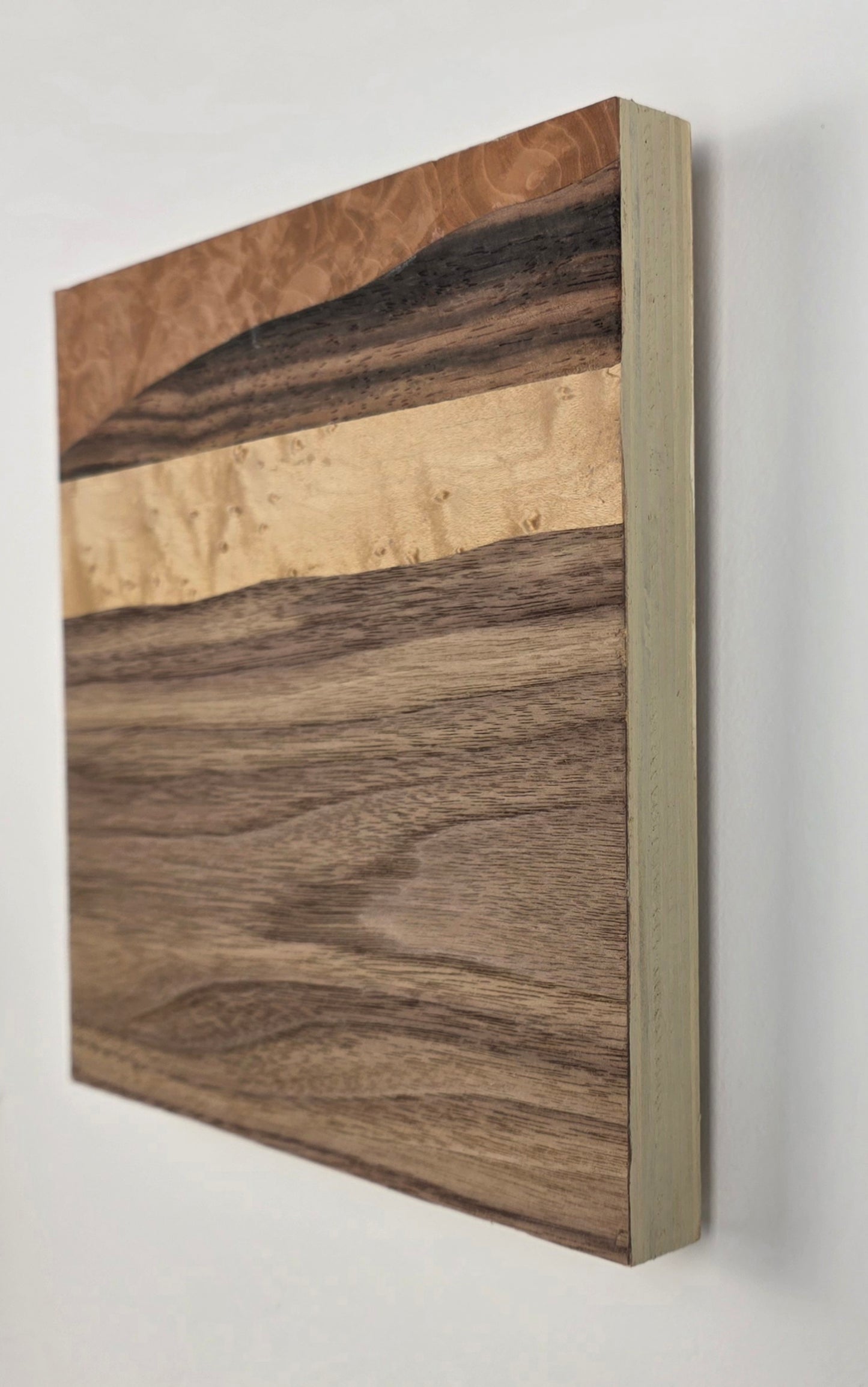 Wooden veneer artwork with a natural grain pattern on a white background
