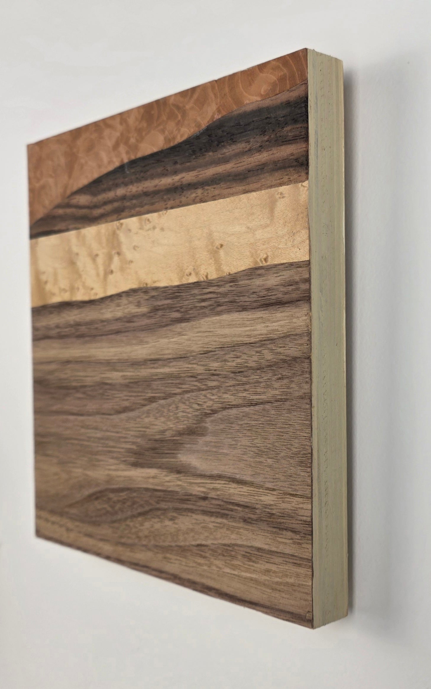 Wooden veneer artwork with a natural grain pattern on a white background