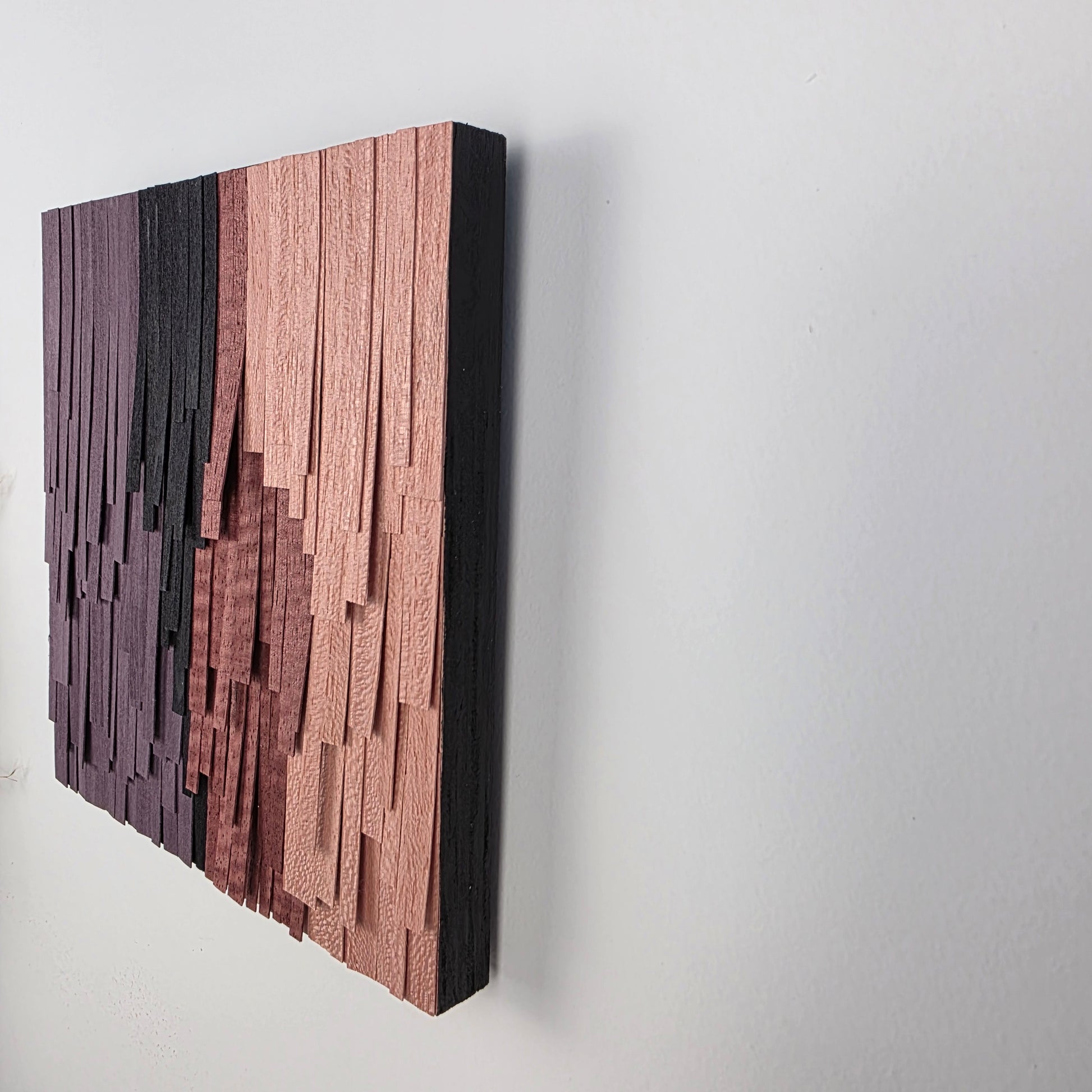 Wooden wall art piece with a geometric pattern on a white background