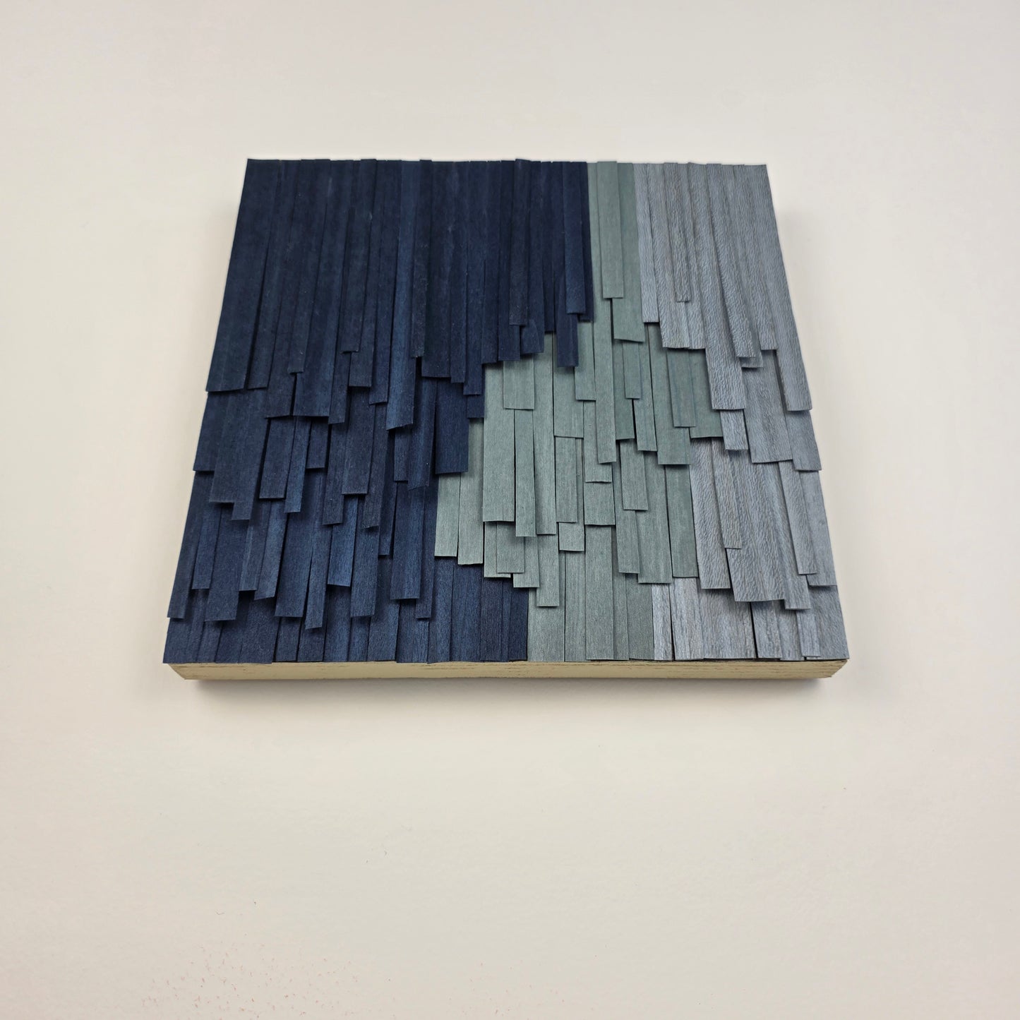 Wooden wall art with a geometric pattern on a plain background