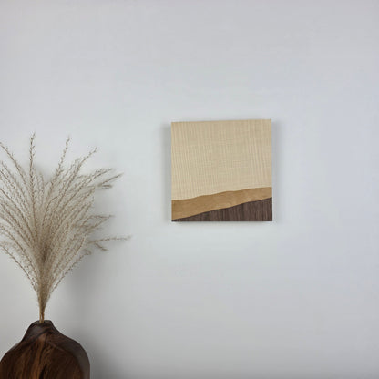 Wood Grain 001 is an original wooden art piece on a white wall with a vase and dried plant in the foreground. Jennifer Mourato Art Collection