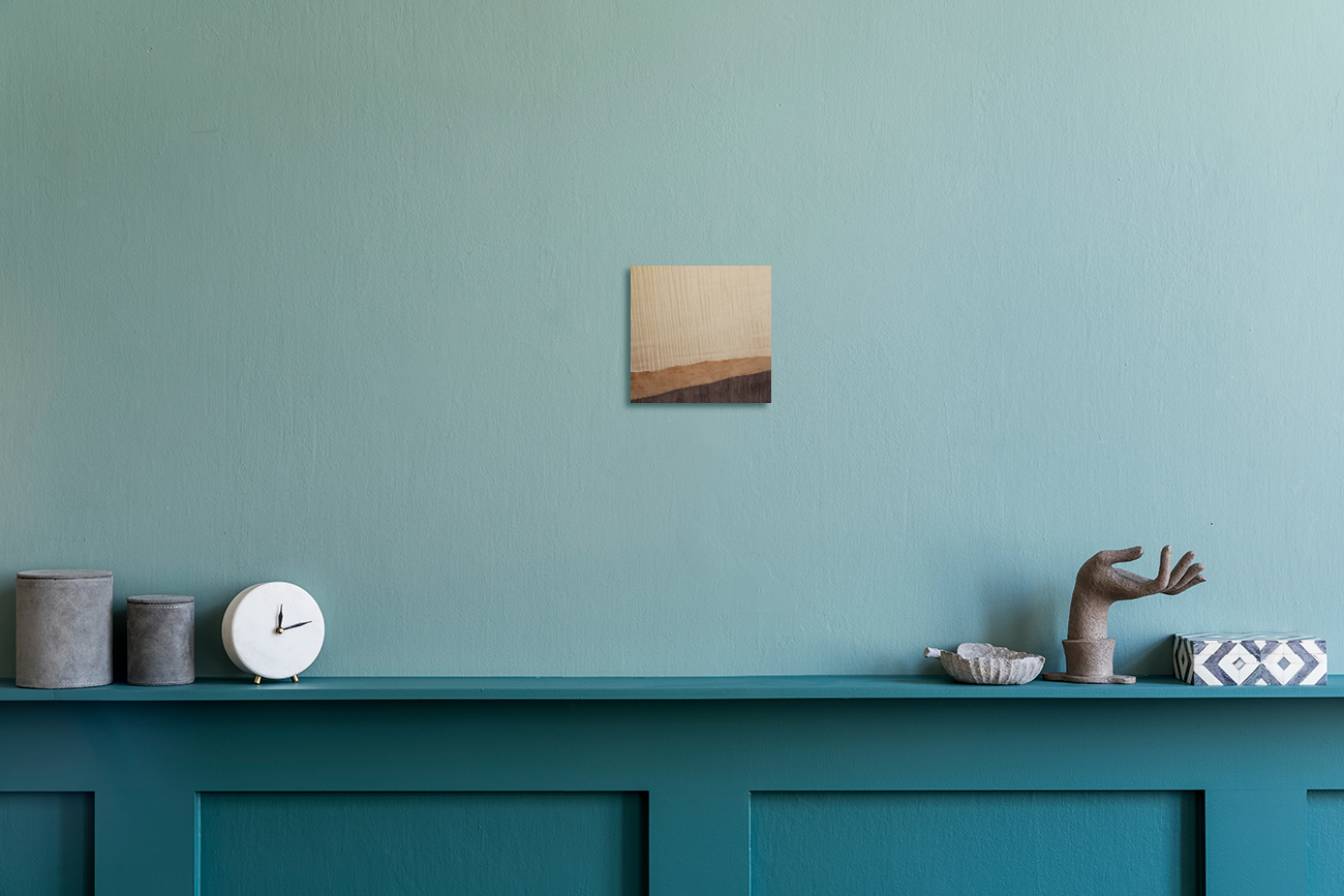 Decorative shelf with a clock, small statue, and abstract artwork against a teal wall. Jennifer Mourato Art Collection