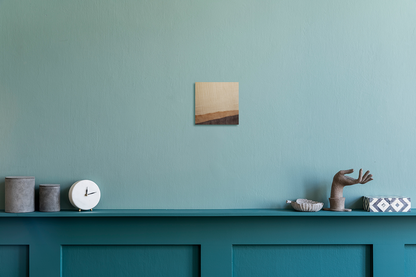 Decorative shelf with a clock, small statue, and abstract artwork against a teal wall. Jennifer Mourato Art Collection